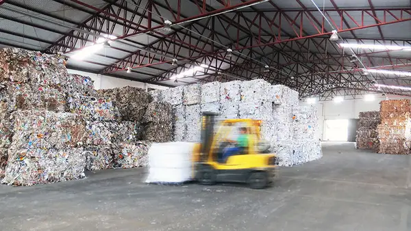 Empilhadeira movimentando fardos de papel
