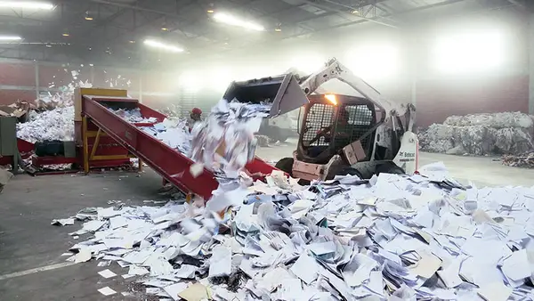 Pá carregadeira sobre aparas de papel