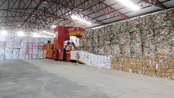 Fardos de papel empilhados dentro do galpão