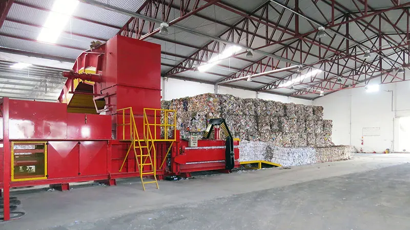 Enfardadeira ao lado de fardos de papel
